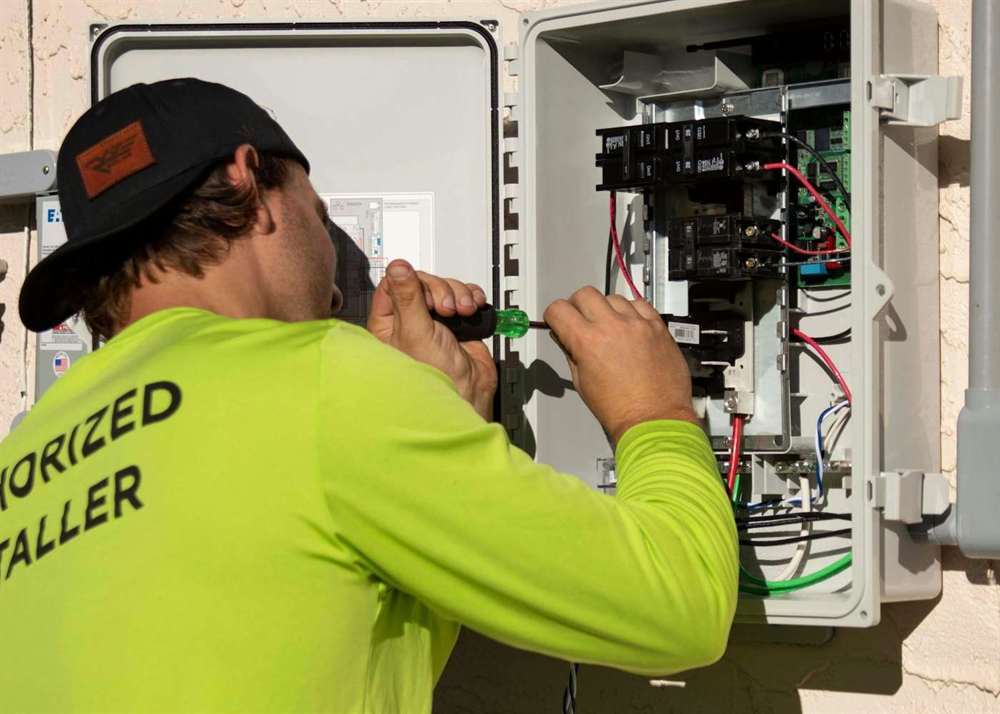 An electrician working inside an open distribution board