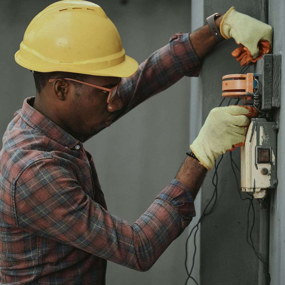 An electrician fitting a socket on a wall
