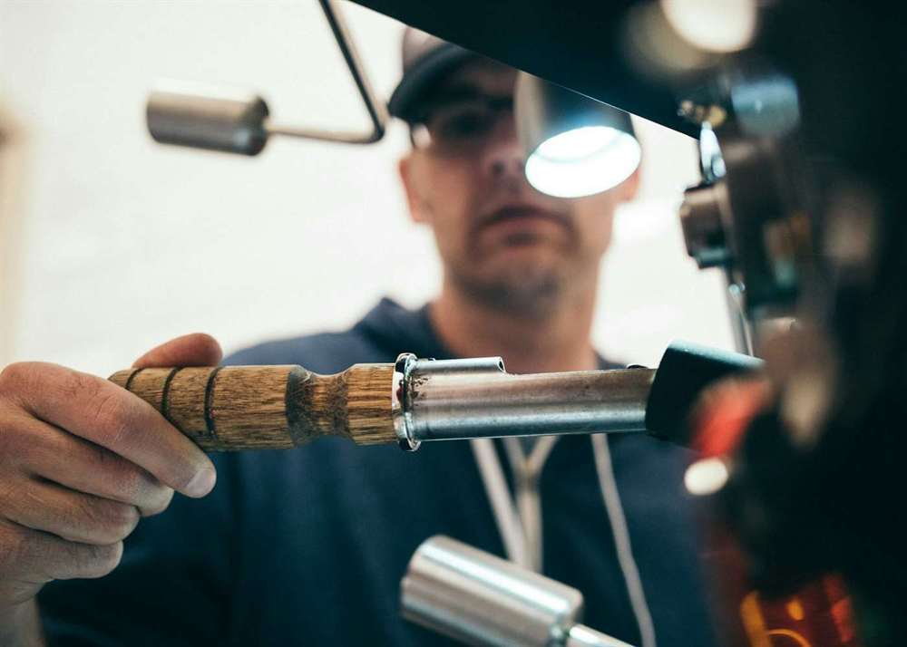 A tradesman holding a tool in a workshop
